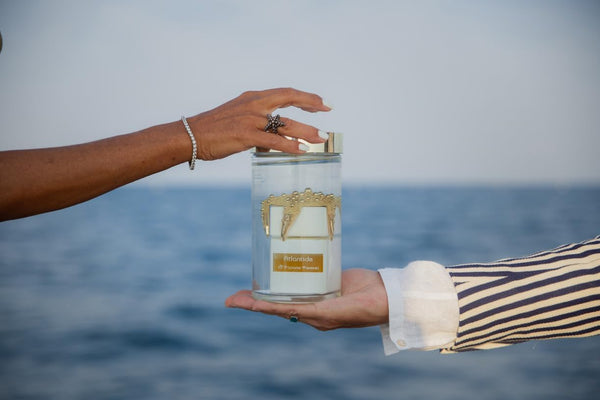 Hand holding the Atlantide bottle out over the sea