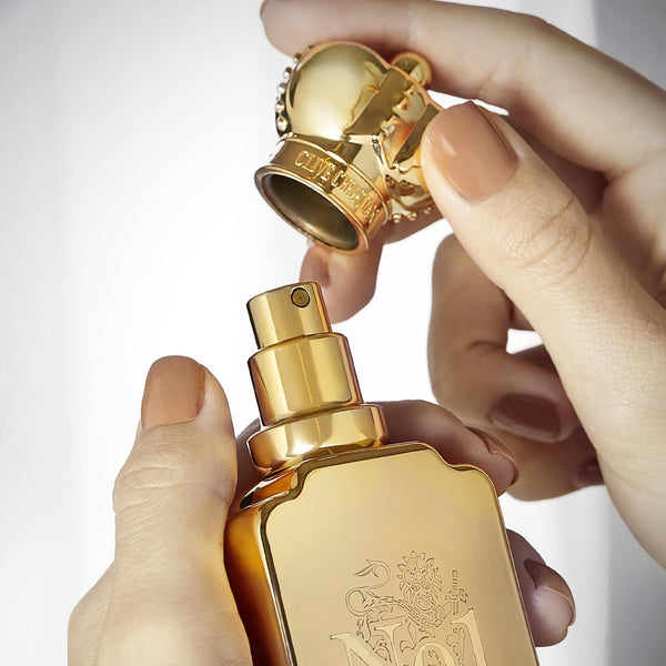 Hand lifting the crown stopper off a Clive Christian No1 bottle