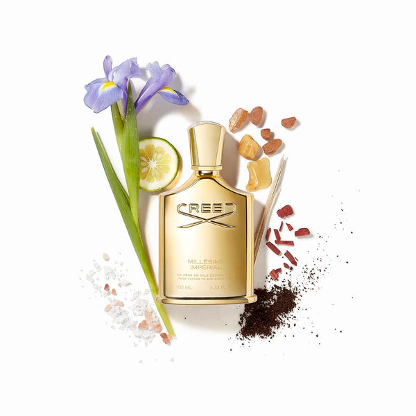 Creed Millésime Impérial bottle surrounded by iris, lemon and other raw ingredients